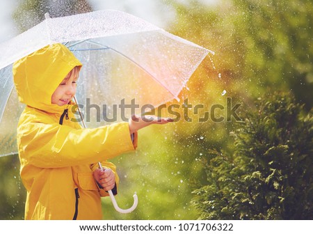 happy kid catching rain drops in spring park Royalty-Free Stock Photo #1071706322