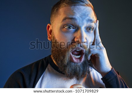 The anger and screaming man. Hate, rage. Crying emotional angry man in colorful bright lights at studio background. Emotional face. Fan human emotions, facial expression concept.