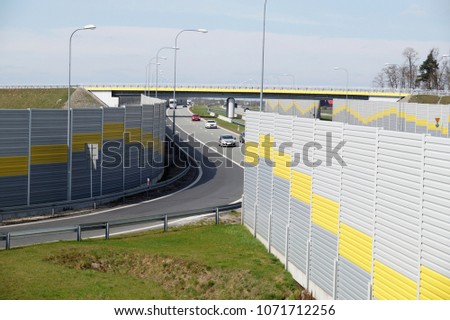 The road is protected against noise emission by noise-absorbing barrier (also called a soundwall, noise wall, noise barrier, sound barrier, or acoustical barrier) is an exterior structure designed to 