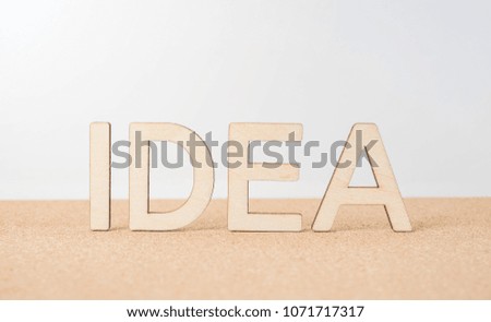 Business and design concept - wooden word " idea " on wooden desktop and white background 
