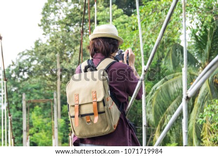Asian woman traveler taking photo with camera in forest Thailand. Travel Concept