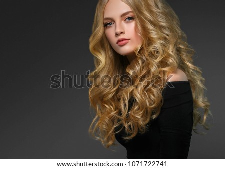 Young beautiful woman model with long beauty blonde curly hair portrait. Beautiful female girl with perfect healthy makeup 