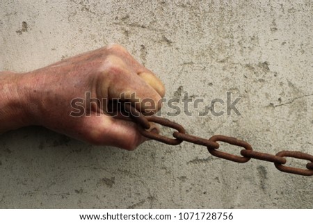 Rusty and old chain clenched in fists.