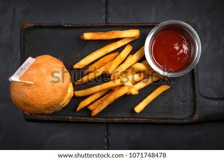 Hamburger, with french fries. Tomato sauce in a steel sauce. Top view.