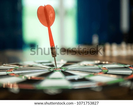 Red dart arrow hit in the target center of dartboard, winner concept, goal concept