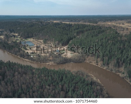 drone image. aerial view of forest river with sandstone cliffs in spring. Gauja, Latvia, sunny day - vintage film look