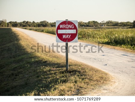 wrong way sign is warning you to turn back from dangers ahead Royalty-Free Stock Photo #1071769289