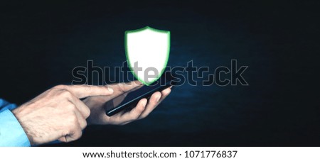 Man holding phone with shield security sign.