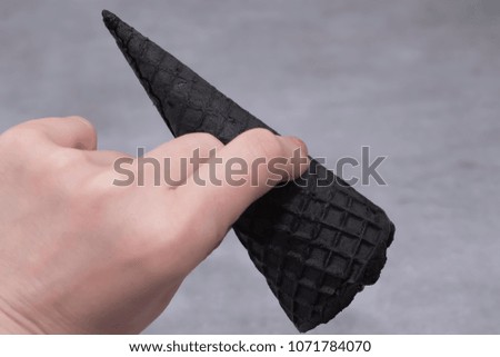 Trendy food. Black ice cream in traditional portioned black cones. Copy space. Soft focus.