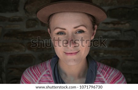 portrait of a young caucasian female hiker wearing a hat standing in a stone hiking shelter