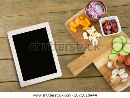 Tablet on wooden desk with food