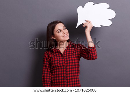 The young business lady holds white paper cloud near his head on a gray background. Student girl has an idea. Idea concept.