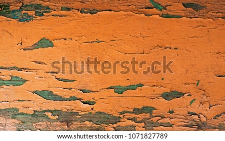 Texture of an old yellow paint on a wooden bench