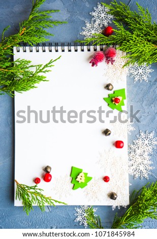 Christmas festive concept with notepad and snowflakes on concrete background with copyspace