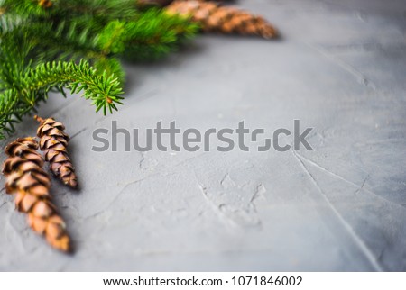 Christmas concept with gift boxes, ribbon and cones on rustic concrete background with copyspace