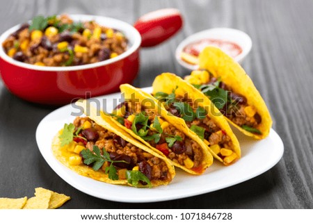 Mexican food - delicious tacos with minced meat, beans and corn