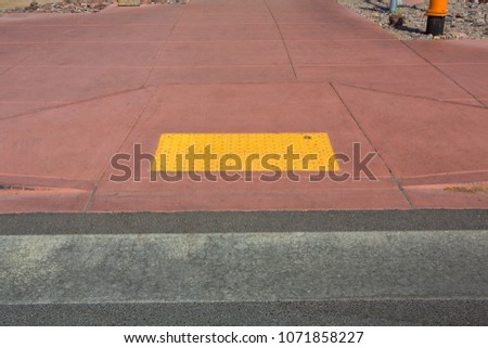 Tactile paving with textured ground surface with markings, indicators for blind and visually impaired. Blindness aid, visual impairment, independent life concept.
