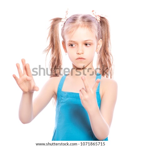 Young seven years old brunette girl in blue dress on a white isolated background. Counting on her fingers, thoughtful emotions on her face