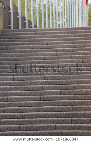 Close up view of a large staircase with a posts row in background. Abstract image of horizontal steps with a blur pattern made of vertical white lines. Architectural urban picture taken in France. 