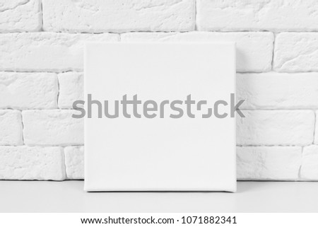 White primed canvas. Mockup poster. White brick wall on background.