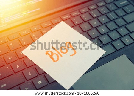 Blog message concept written post it on laptop keyboard