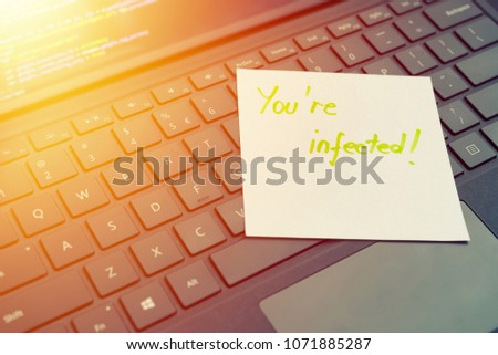 You're infected message concept written post it on laptop keyboard
