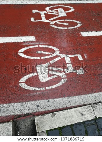 Bicycle symbol on red bicycle lane wet by rain
