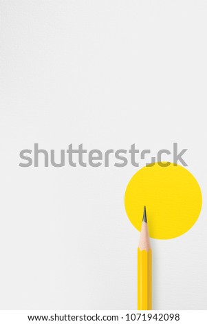 Vertical template with copy space by top view close up macro photo of yellow pencil isolated on texture white paper and combine with yellow circle. Flash light made smooth light on yellow pencil.