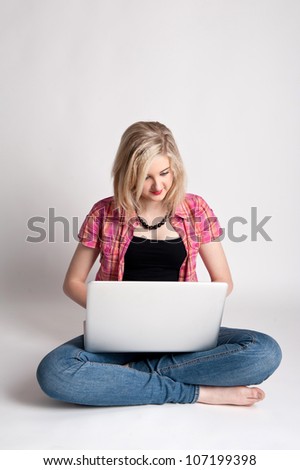 Pretty girl working on a laptop against white background.