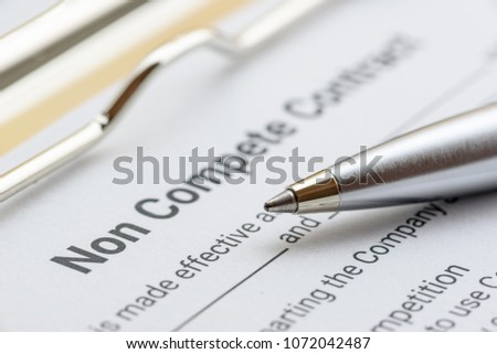 Blue pen and a non compete contract on a clipboard. Noncompete contract is an agreement between employee and employer, not to enter into competition in subsequence business effort. Legal form concept. Royalty-Free Stock Photo #1072042487