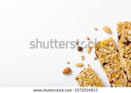 Energy bar of muesli with nuts, berries and oat flakes on a white background. Healthy food, granola for breakfast. Top view. Royalty-Free Stock Photo #1072054853