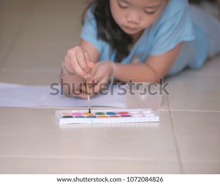 Little girls are practicing drawing. Watercolor paper is cooled down in order to learn the art.