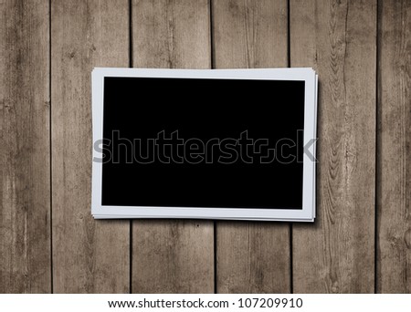 Stack of blank photographs at grunge wooden background with clipping path for the inside of the photo