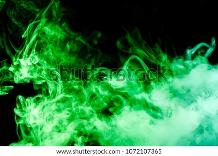 Colorful green smoke  on a black isolated background. Background from the smoke of vape