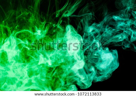 Thick colorful  green smoke on a black isolated background. Background from the smoke of vape
