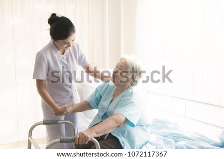 Nurse with patient. Routine health check and assisting elderly patient to walk. Female nurse with senior chinese woman. Royalty-Free Stock Photo #1072117367