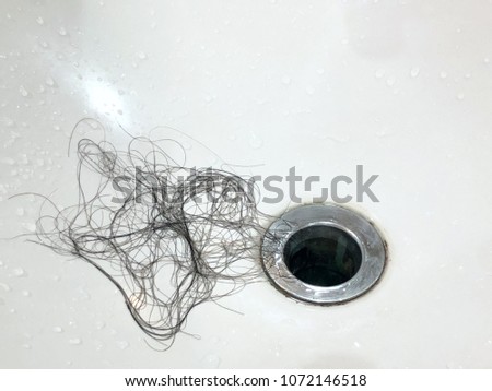 Young woman brushing her hair. Many hair loss on filter in washbasin in bathroom. May be clog. Healthcare concept. Copy space. Royalty-Free Stock Photo #1072146518
