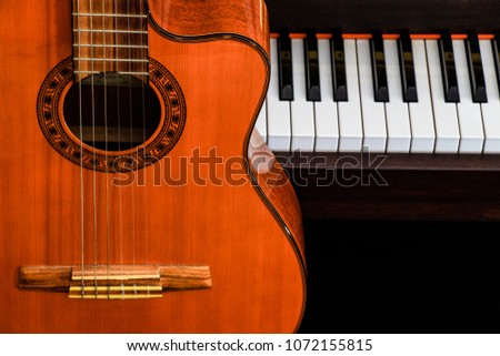 close up of classic guitar over piano keys for music background with copy space