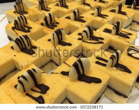 Vanilla cakes with topping nut and chocolate are on the tray at restaurant