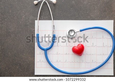 Cardiogram with stethoscope on table