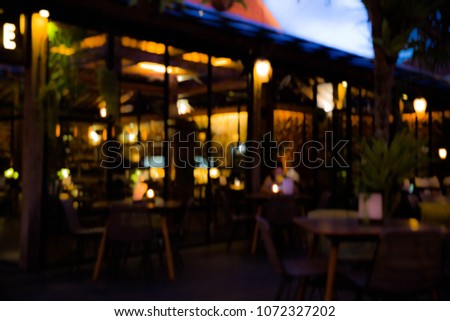 Blurred background : Restaurant with tables and chairs blur background with bokeh light. Evening time