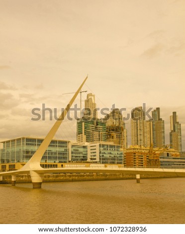 View of the old harbor area (Puerto Madero) by sunset, Buenos Aires, Argentina. On the left, modern offices. In the middle, the Woman bridge on the Rio de la Plata (Silver River).