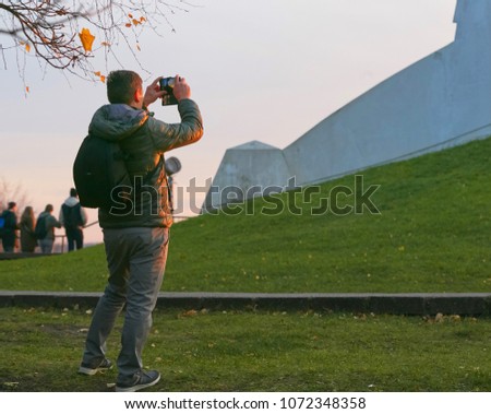 tourist takes pictures at sunset by phone