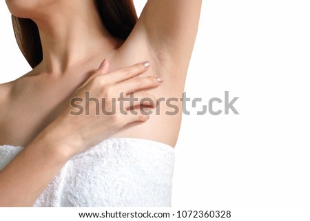 Closeup of a beautiful young woman showing her smooth armpit isolated on white background. Girl holding her arms up and showing clean underarms. Royalty-Free Stock Photo #1072360328