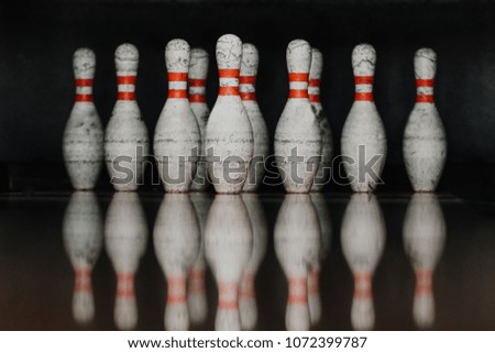 grungy bowling pins in gate with reflection in polished floor