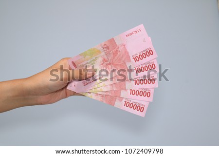 woman hand showing rupiah Indonesian money Royalty-Free Stock Photo #1072409798