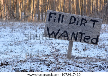 Fill Dirt Wanted sign in a snowy field. 