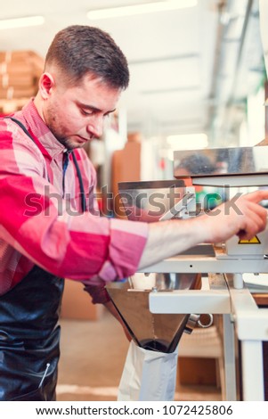 Photo of young businessman with paper bag next to apparatus
