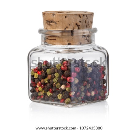 Red, black and white peppers in a glass bottle. Isolated on white backgroundwith clipping path