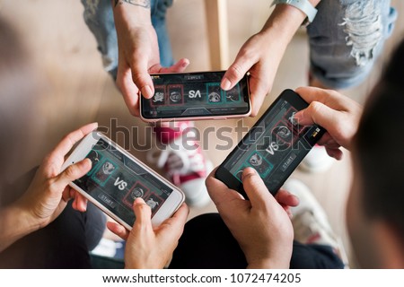 Group of diverse friends playing game on mobile phone Royalty-Free Stock Photo #1072474205